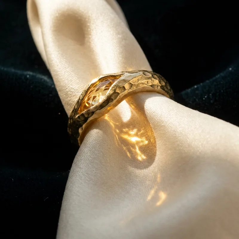 Generated ad visual — hammered gold ring on silk