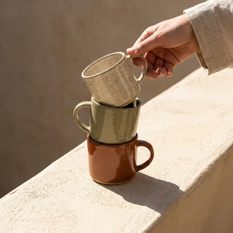 Generated ad visual — stacked glazed ceramic mugs