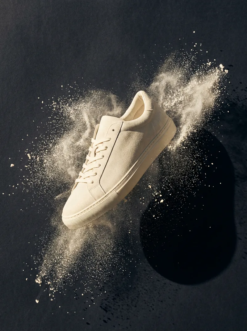 Generated ad visual — sneaker mid-air in chalk dust