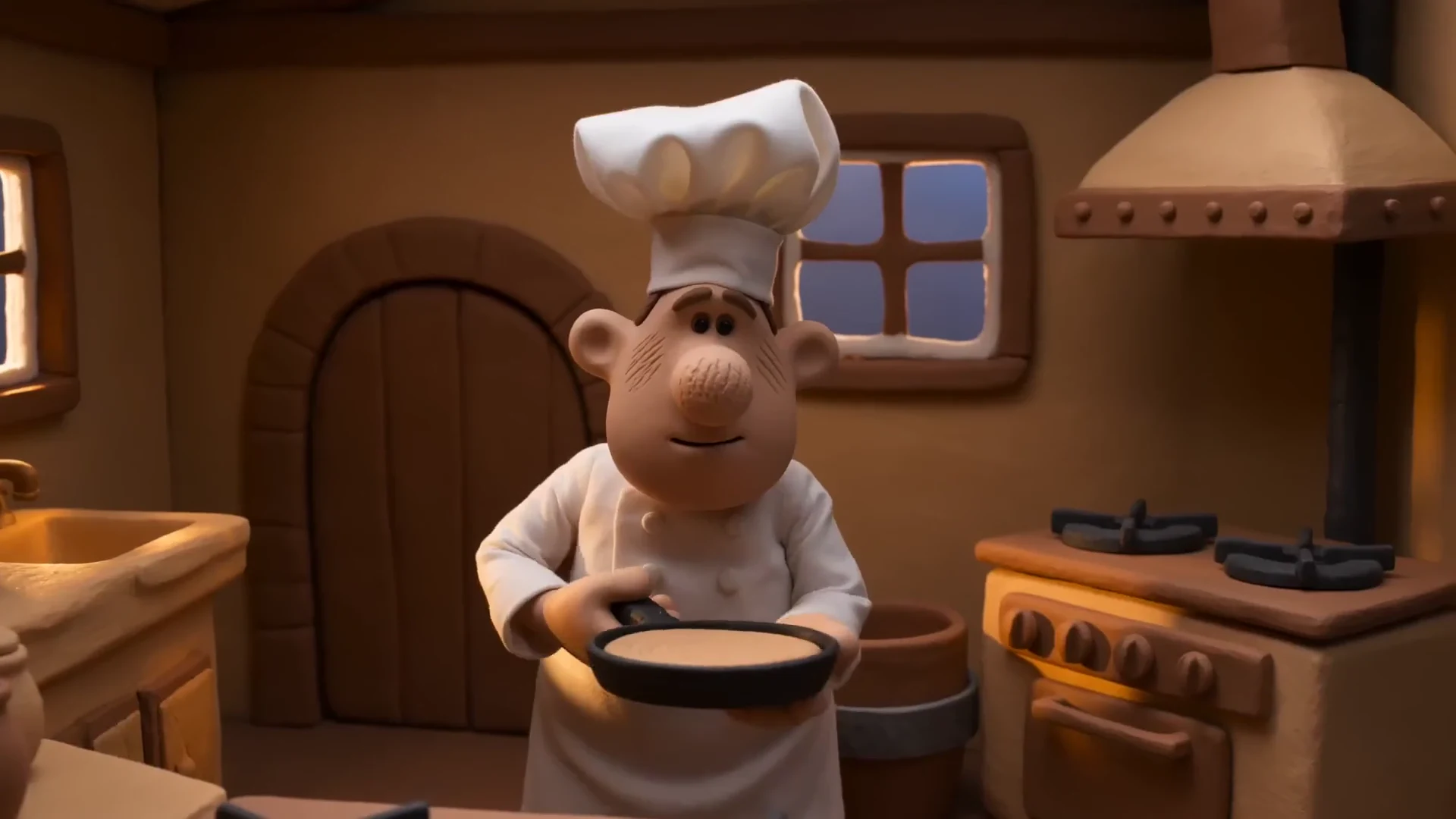 A miniature clay chef flips a pancake in a warmly lit kitchen. Silent animation.